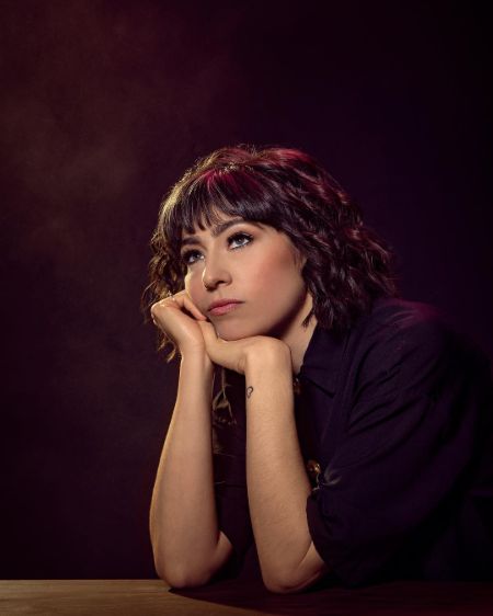 Melissa Villaseñor in a black t-shirt poses for a picture.